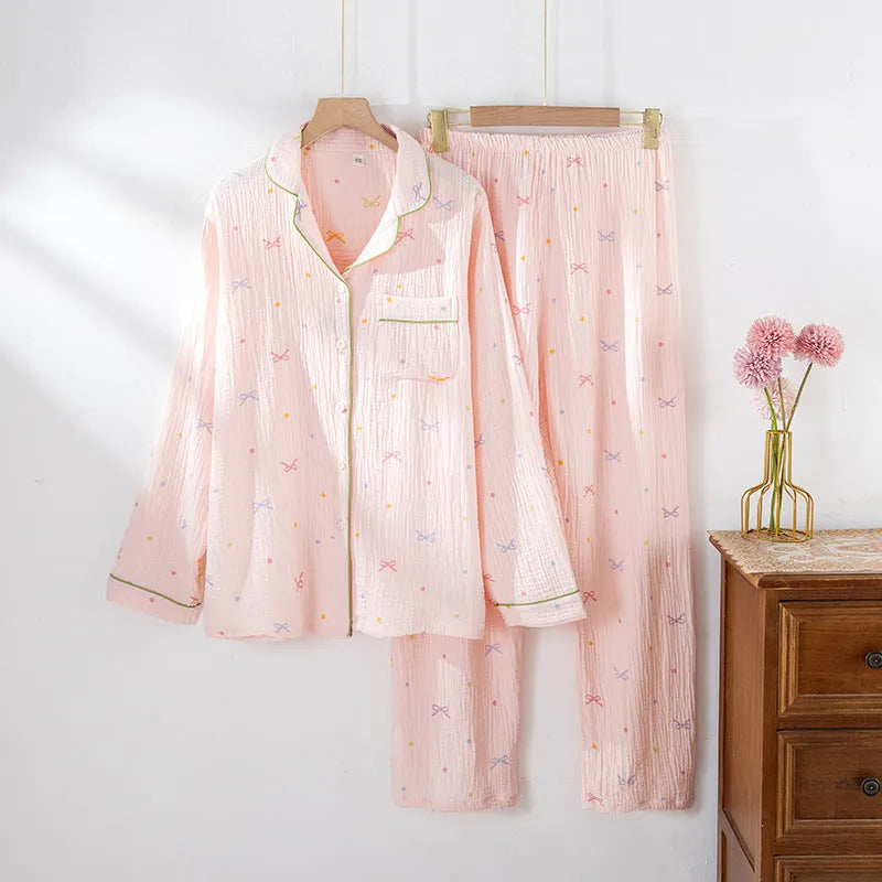Women's pink cotton pajama set with long sleeves and trousers, laid flat.