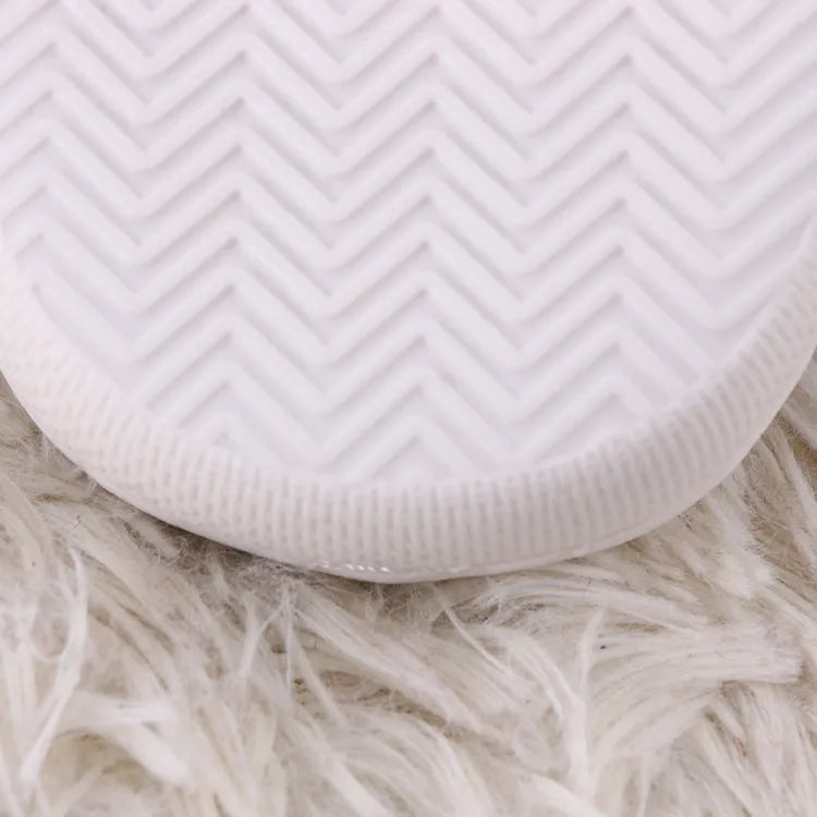 White fluffy slippers with cartoon patterns, rubber soles, and toe holder design