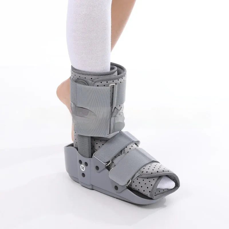 Black Achilles tendon rehabilitation boot with aluminium uprights on a grey background.