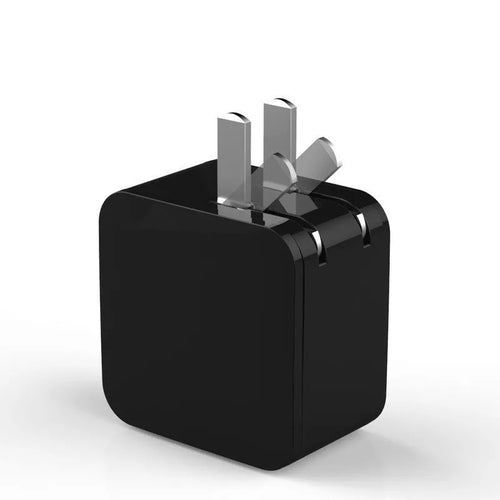Black dual USB fast charger with digital display showing charging current, plugged into a UK wall socket.