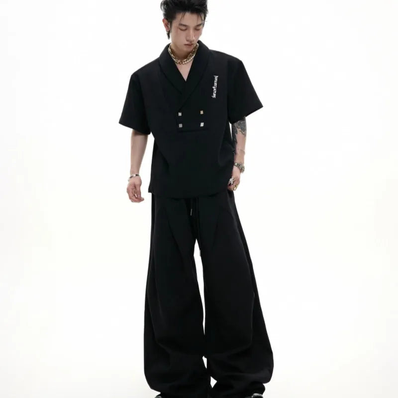 Men's dark grey cotton sports suit with V-neck jacket, padded shoulders, metal embellishments, and matching shorts.
