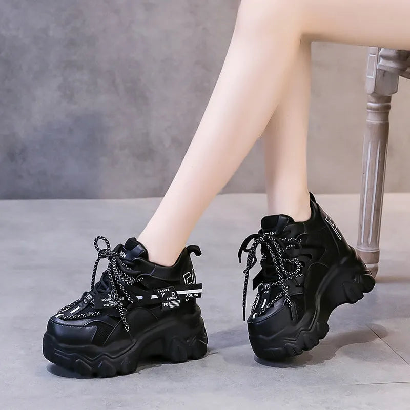 Women's white and black platform tennis shoes with mesh upper and cross-strap.