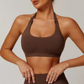 Women's black halter-style yoga sports bra with medium support and built-in chest pads.