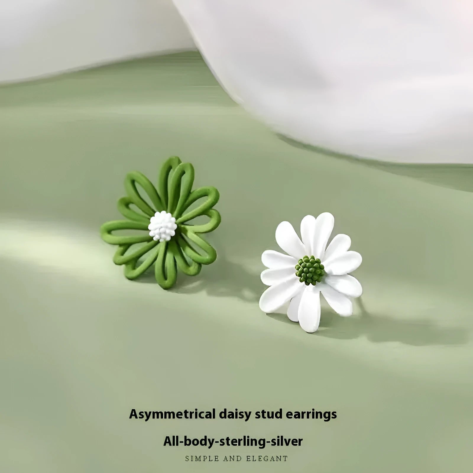 Close-up of colourful alloy flower stud earrings showing white and green two-tone design.