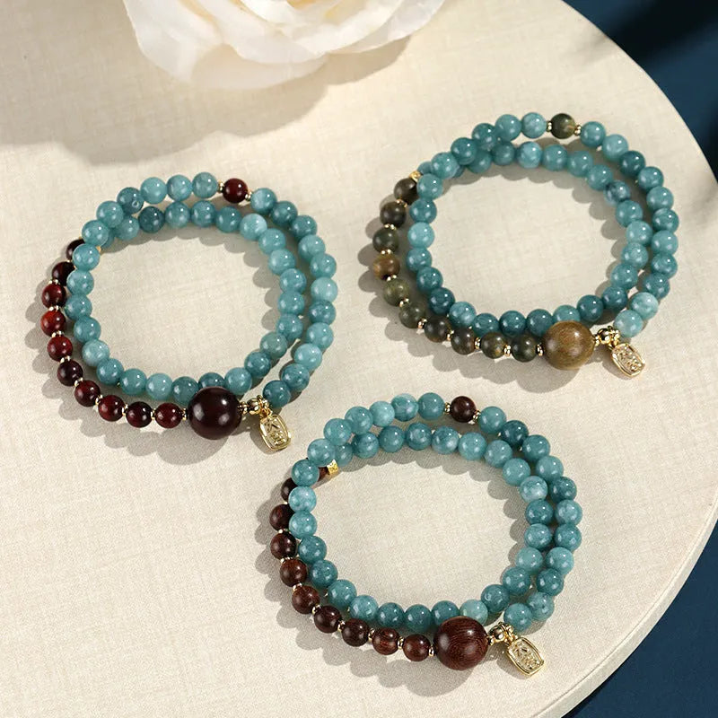 Close-up of a blue electroplated women's beaded bracelet with geometric and Fu/Xi character charms in New Chinese style.