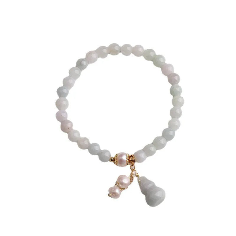 Women's handmade jade bracelet with traditional gourd charm design and pearl accents in natural emerald green colour