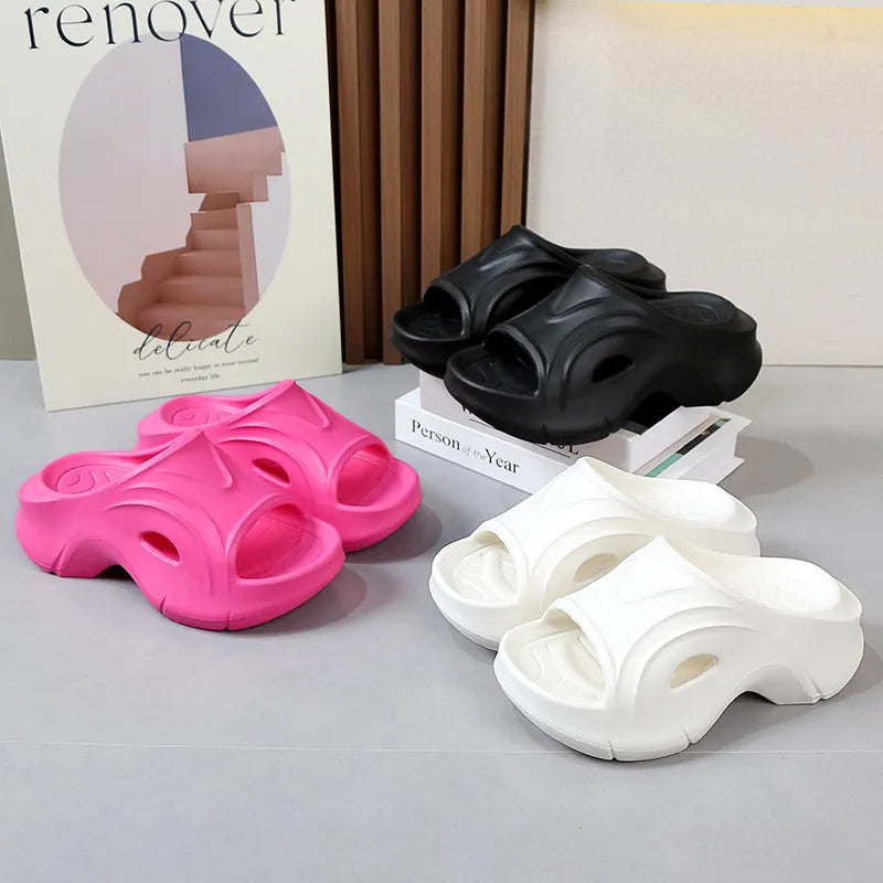 Women's white thick-soled EVA slippers on a sandy beach background.