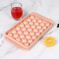 Blue silicone ice cube tray with lid showing 33 round cavities.