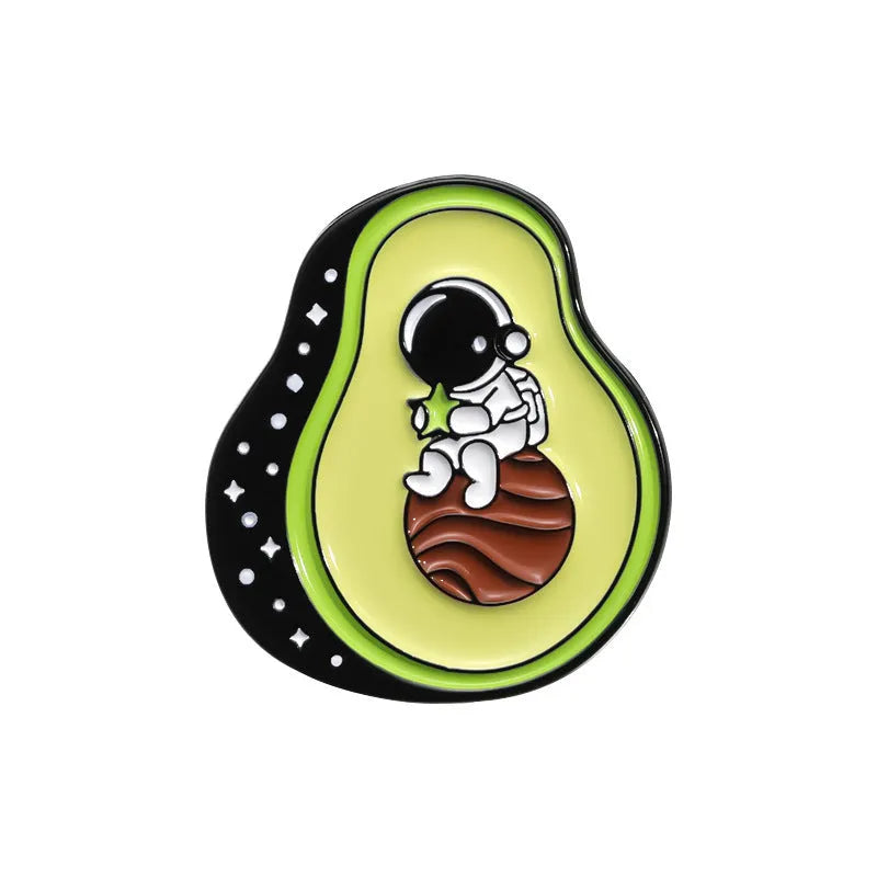 Colourful cartoon fruit and letter design on a metal brooch pin with a secure clasp.