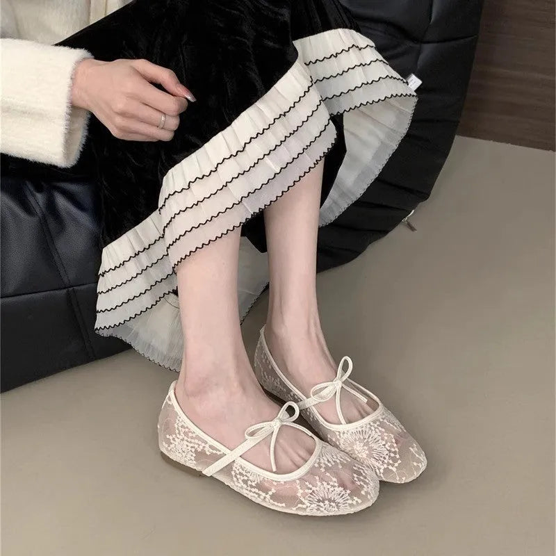 Women's pink flat lace mesh Mary Jane evening shoes with a mid heel on a white background.