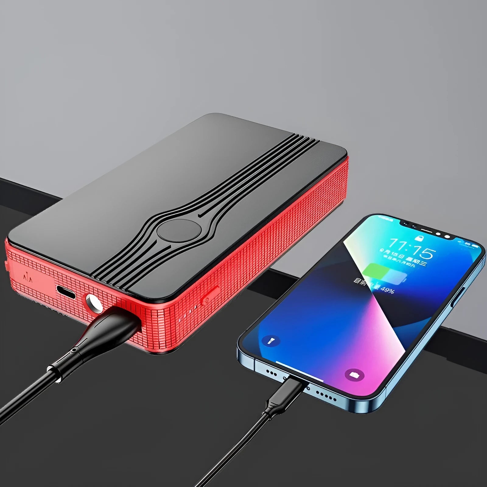 Red K4-E automobile emergency jump starter power supply unit with a USB cable on a table.