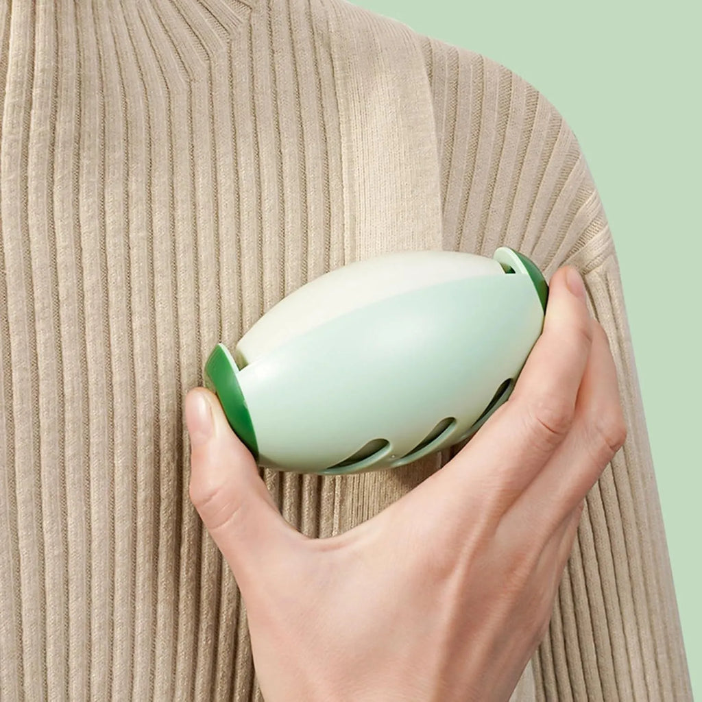 Green and white washable reusable gel lint roller ball for pet hair removal on fabric.