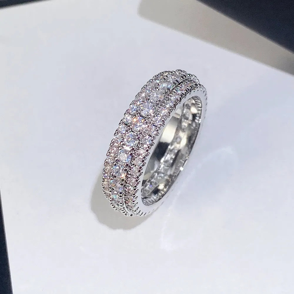 A geometric triangle-shaped ring with a zircon stone inlay, shown in a choice of metal colour finishes.