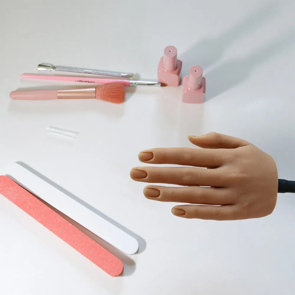 Silicone nail art practice hand model with movable fingers on a table.