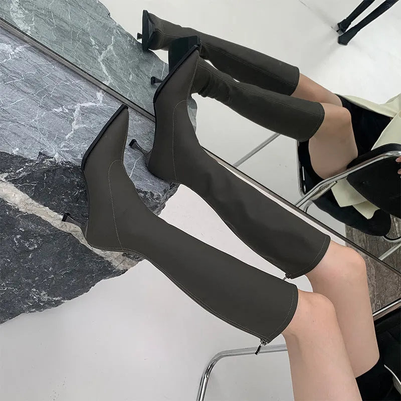 Black pointed toe women's boots with stiletto heel and back zipper, shown from the side.
