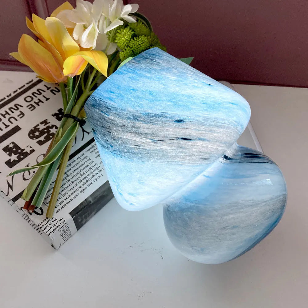 Handmade glass mushroom table lamp in Earth colour on a wooden bedside table with a soft glow