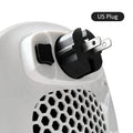 White ceramic electric heater with remote control on a table, dual voltage for EU and US plugs.