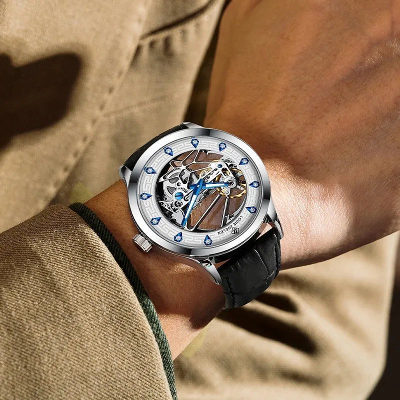 Men's silver-cased mechanical watch with white dial, blue hands, black leather strap, and butterfly buckle.