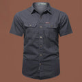 Man wearing a loose-fit army green short sleeve cotton work shirt with a cardigan style.