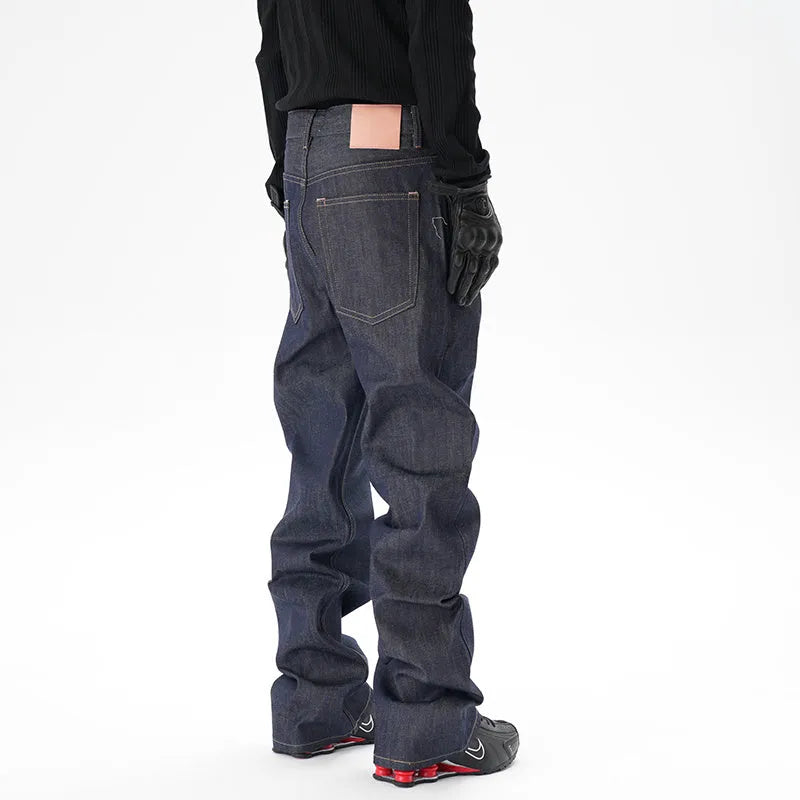 A pair of dark blue loose straight-cut jeans laid flat, showing the front design.