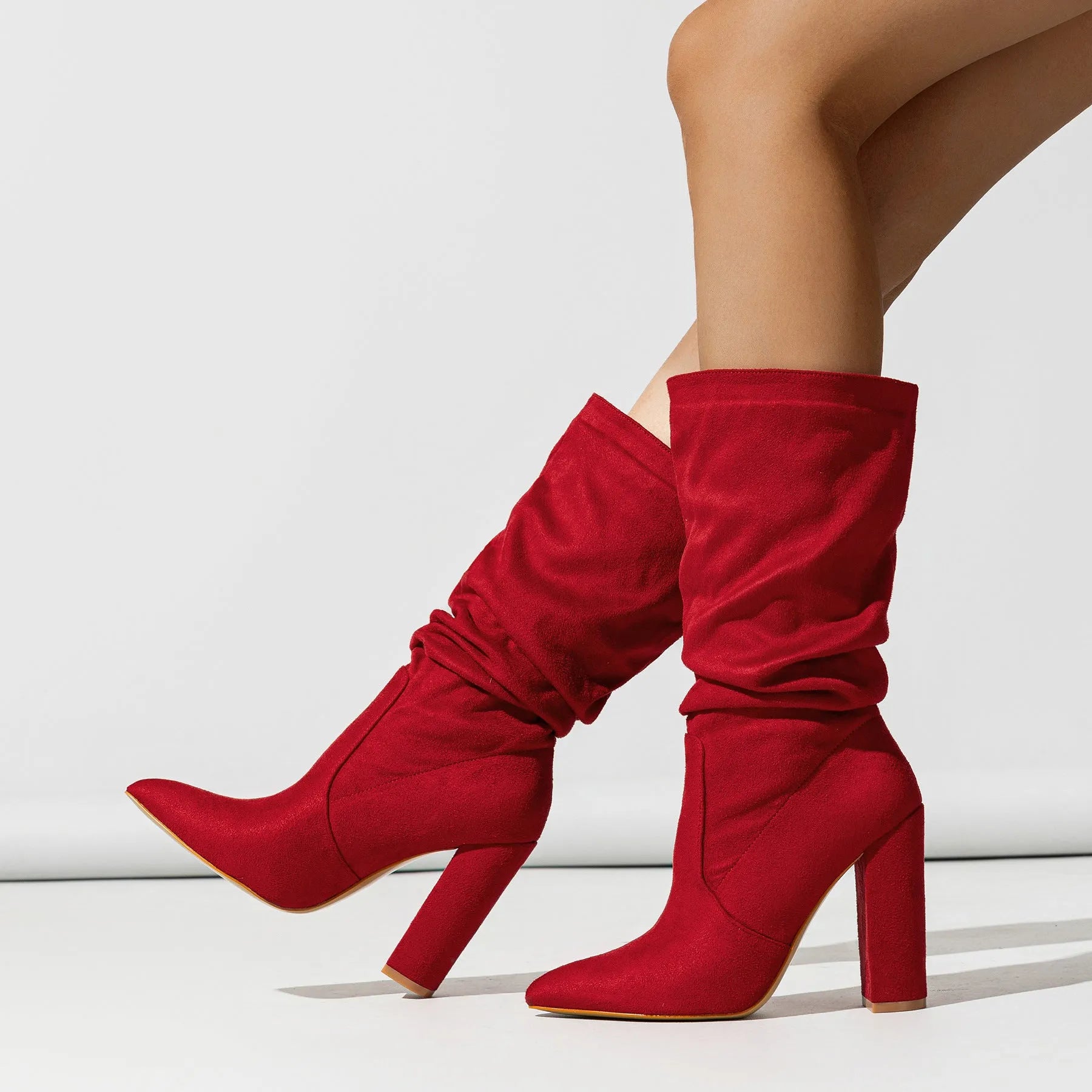 Women's black suede pointed-toe boots with a chunky high heel and mid-calf length