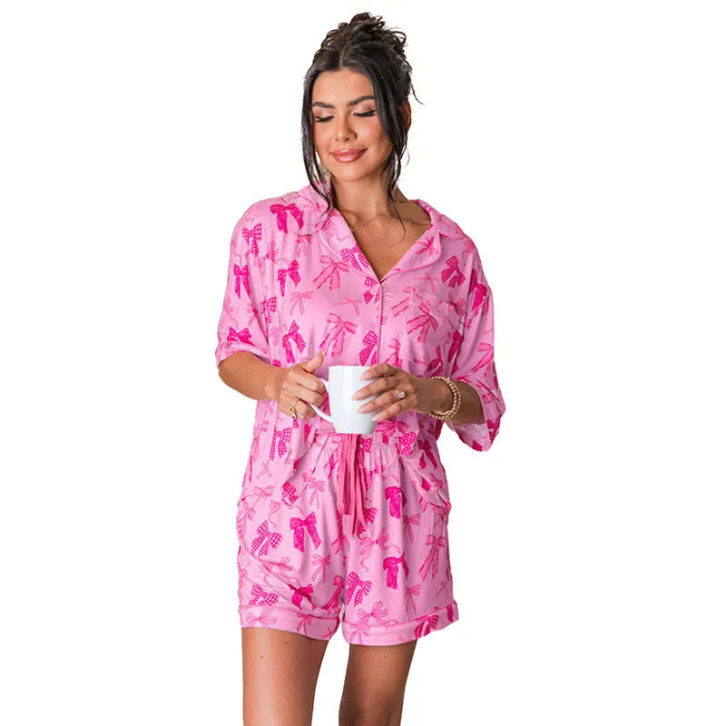 Pink bow print pyjama set with a top and pants, made from lightweight polyester fabric.