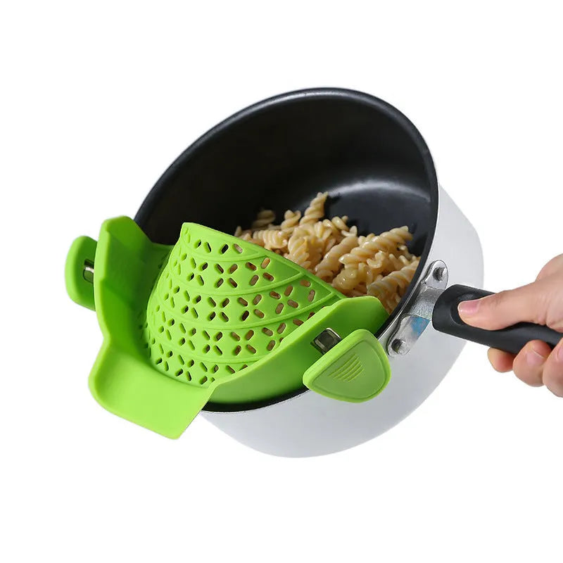 Green silicone pot side drain stopper kitchen gadget with stainless steel on wooden surface