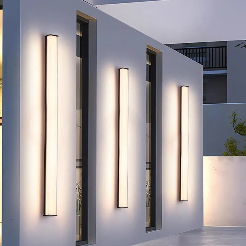 Modern outdoor wall lamp mounted on an exterior wall, showcasing its simple design.