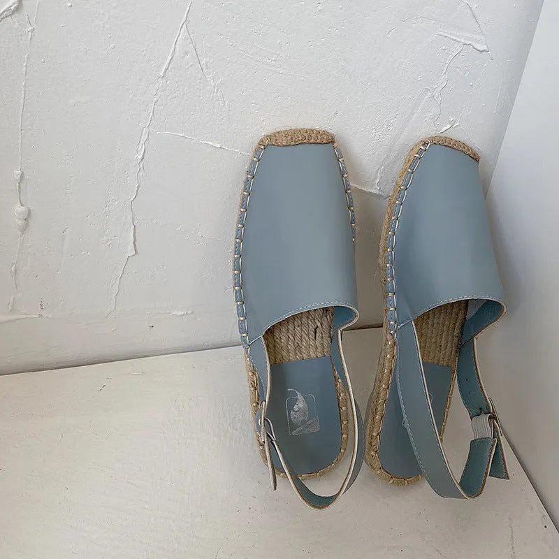Women's beige canvas fisherman flat sandals with leather trim and animal print, shown on a flat sole.