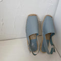 Women's beige canvas fisherman flat sandals with leather trim and animal print, shown on a flat sole.
