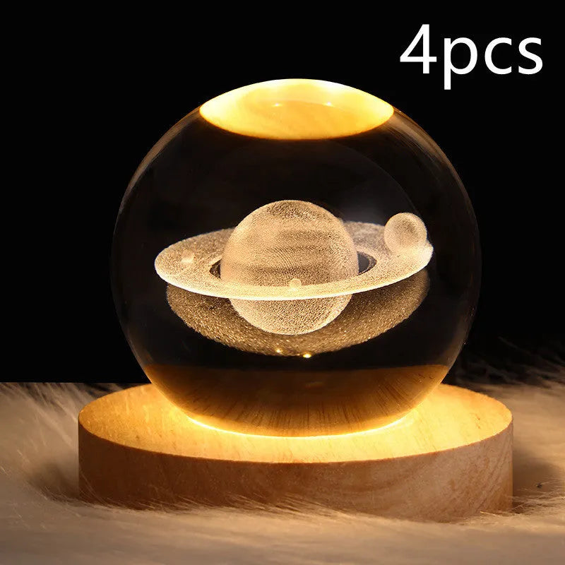 LED galaxy crystal ball night light with 3D planet designs on a table