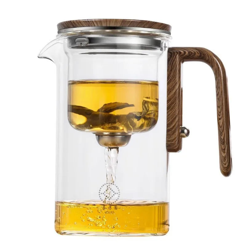 Chinese-style glass teapot with wooden handle showing magnetic filtration button and inner infuser container.