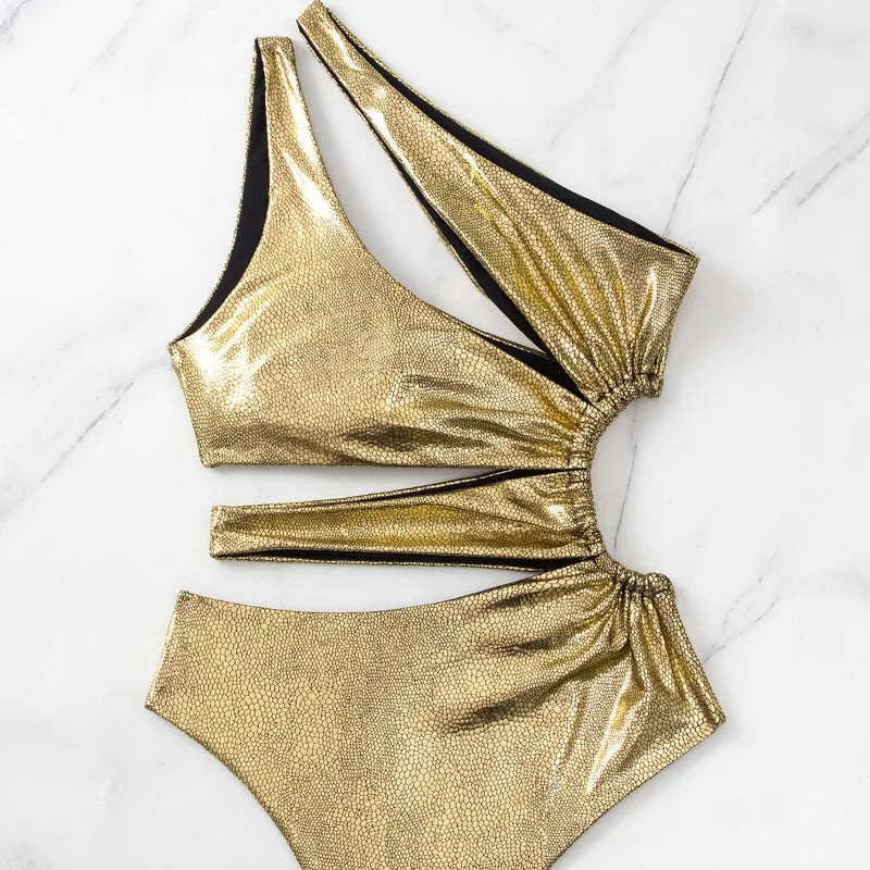 Gold coloured backless one-piece swimsuit for women on a hanger.