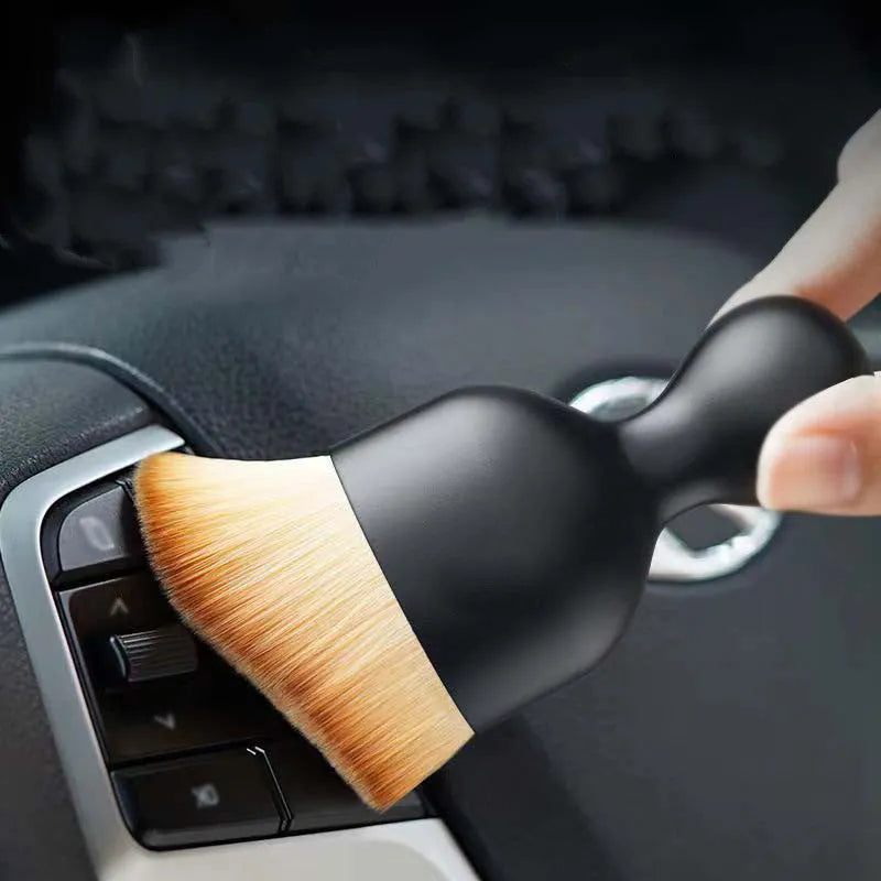 Compact white PVC soft-bristle brush for cleaning car dashboard vents and interior dust.