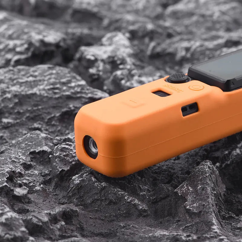 Black silicone protective sleeve cover for a PTZ camera motor body, shown next to red and orange versions.