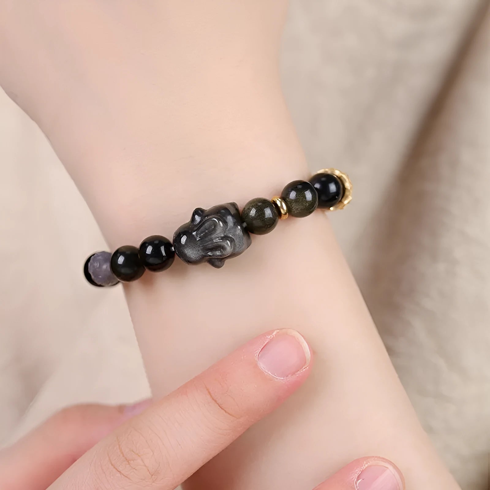 Handmade obsidian bracelet with lying rabbit charm, grey agate beads and brass metalwork in national style