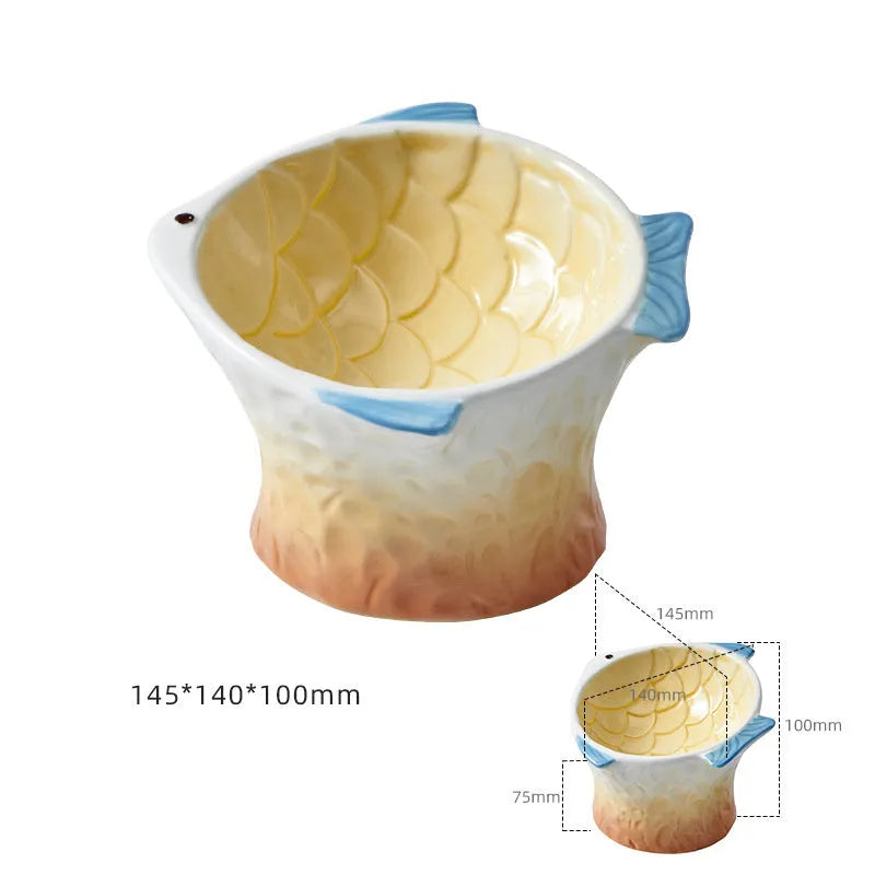 Set of blue fish-shaped ceramic cat bowls with a tilted angle on a wooden surface.