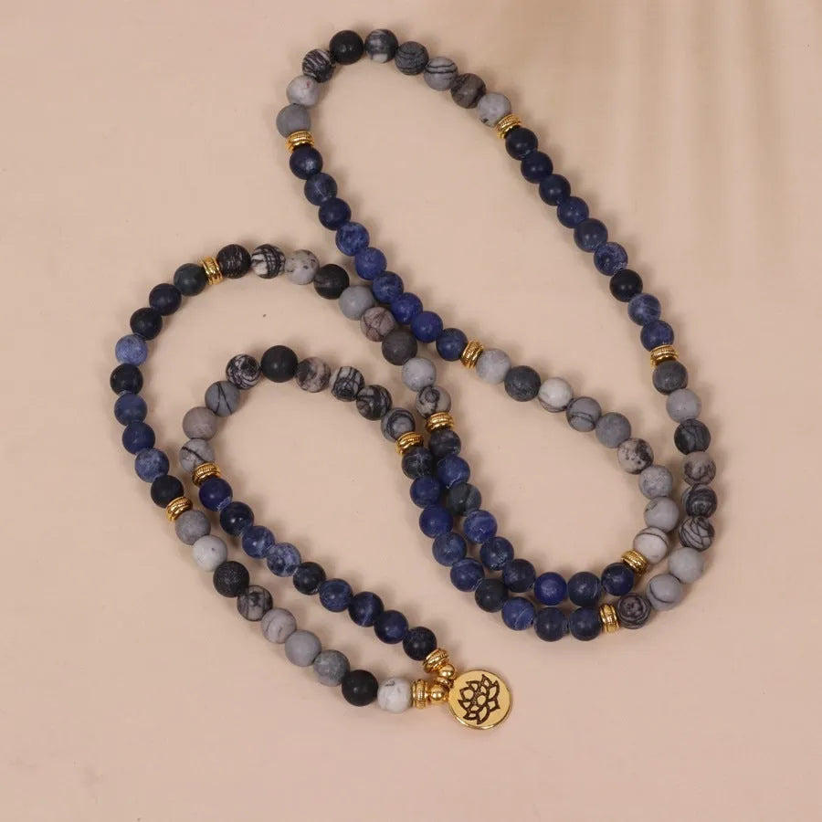 Close-up of a blue patterned network stone bead multi-layer alloy bracelet on a wrist.