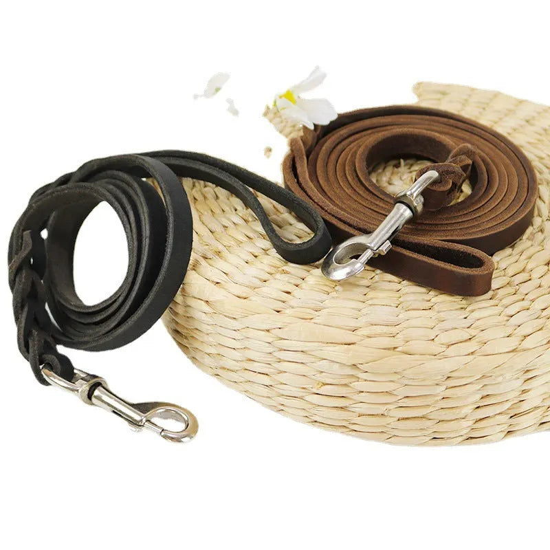 Thickened brown cowhide dog walking rope held in a hand, showing its length and simple strip design.