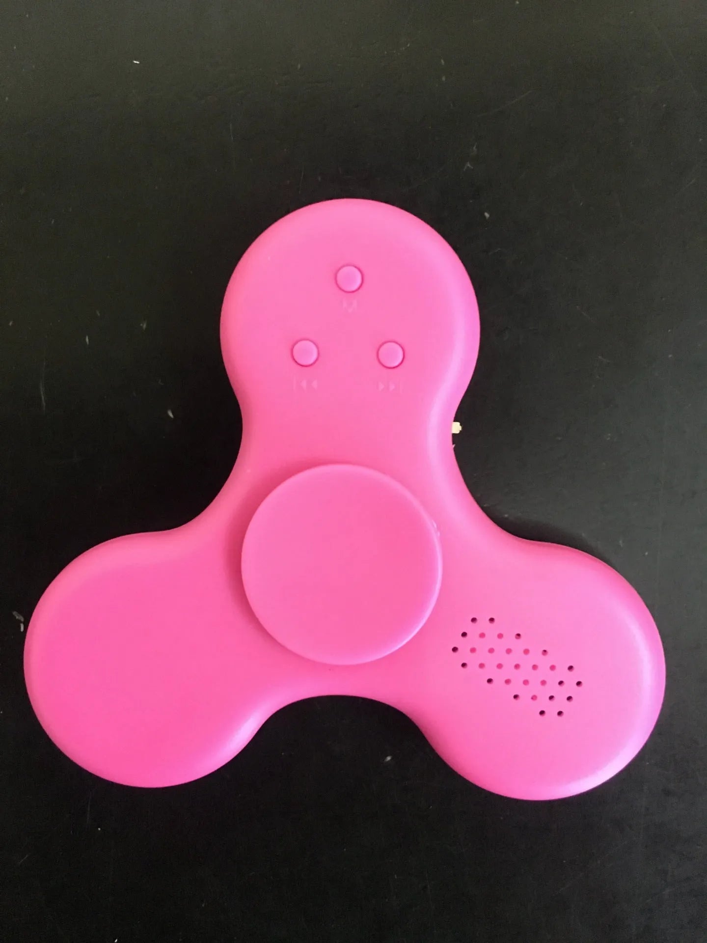 A square blue Bluetooth speaker and MP3 player with an integrated fidget spinner, showing button controls.