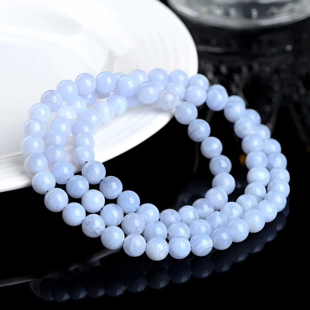 Blue agate bracelet with multi-circle pattern and scattered striped beads on a wrist.