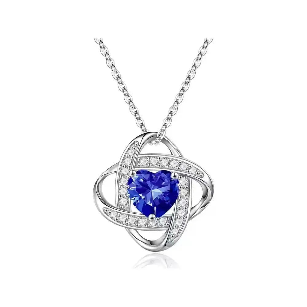 Close-up of a ladies heart-shaped love necklace pendant in a platinum colour finish on a model.