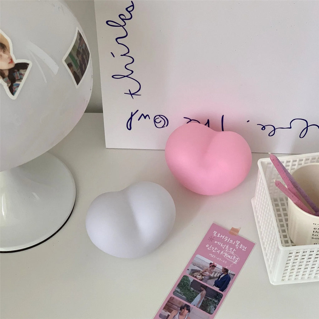 White or pink vinyl trumpet-shaped atmosphere lamp glowing warmly on a surface