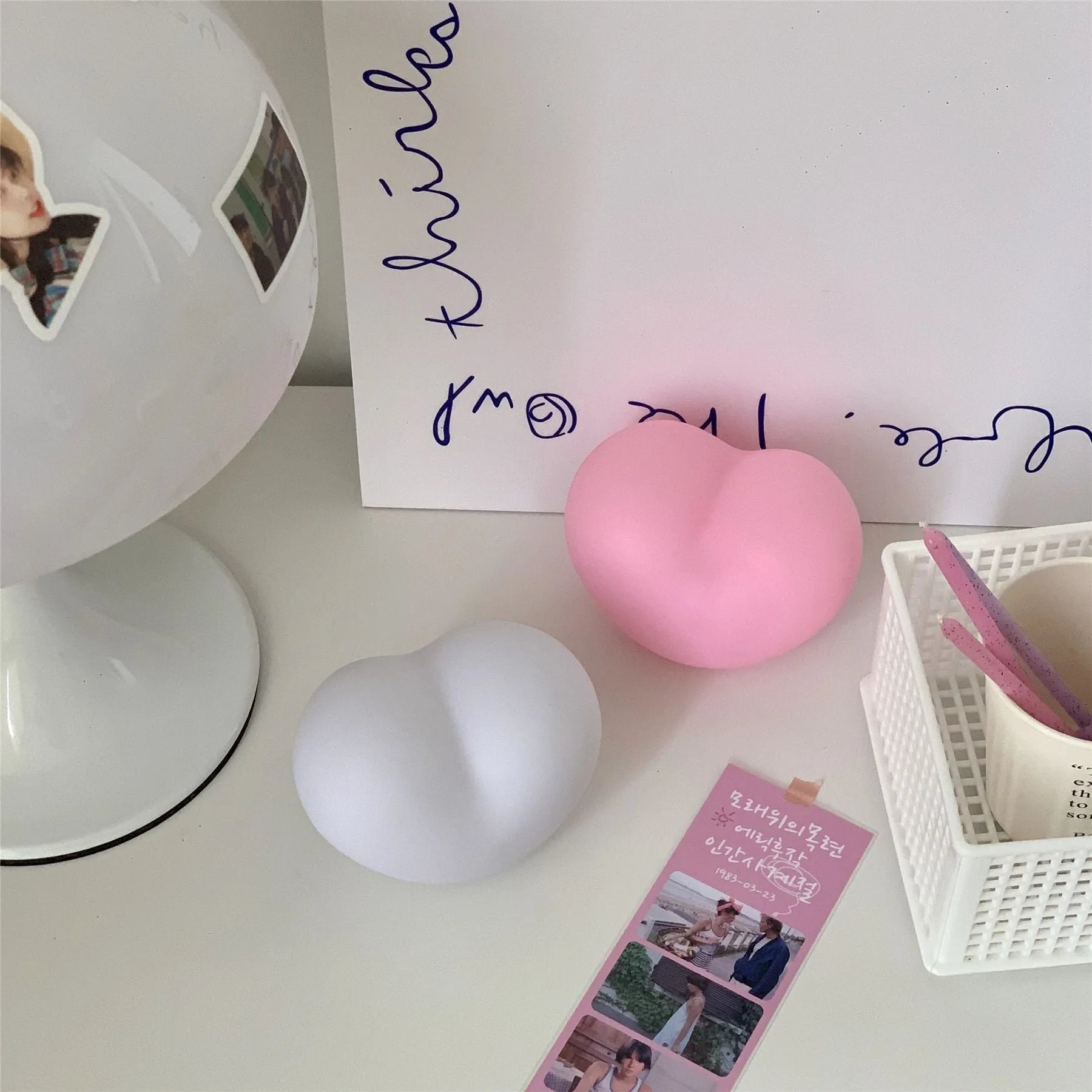 White or pink vinyl trumpet-shaped atmosphere lamp glowing warmly on a surface