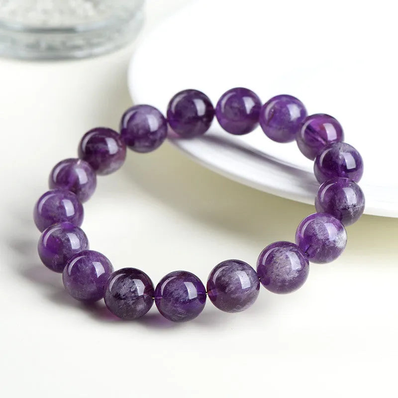 Natural purple feather amethyst crystal bracelet with geometric design and Ruyi element on wrist.