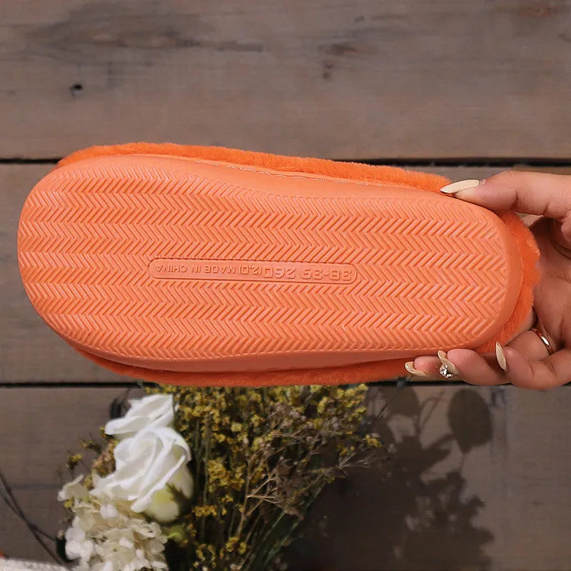 Orange Halloween pumpkin-themed plush slippers with a coral velvet upper and flat heel.