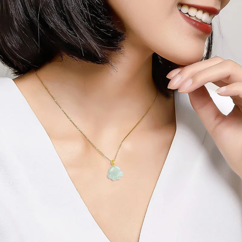 Emerald light green jade cat's paw pendant with 18K gold buckle and certificate on a white background
