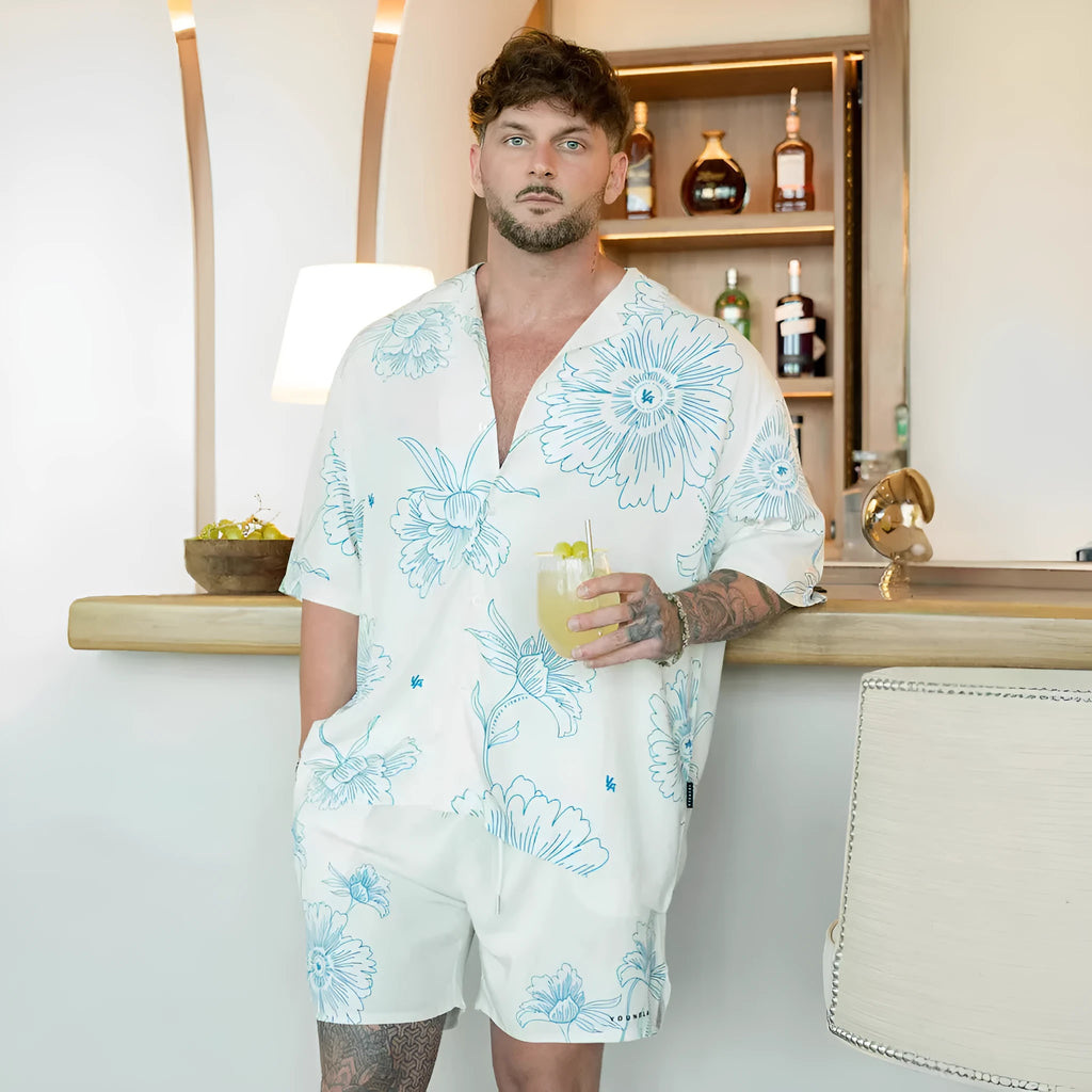A loose-fitting short sleeve top with a floral print in a light colour, laid flat.
