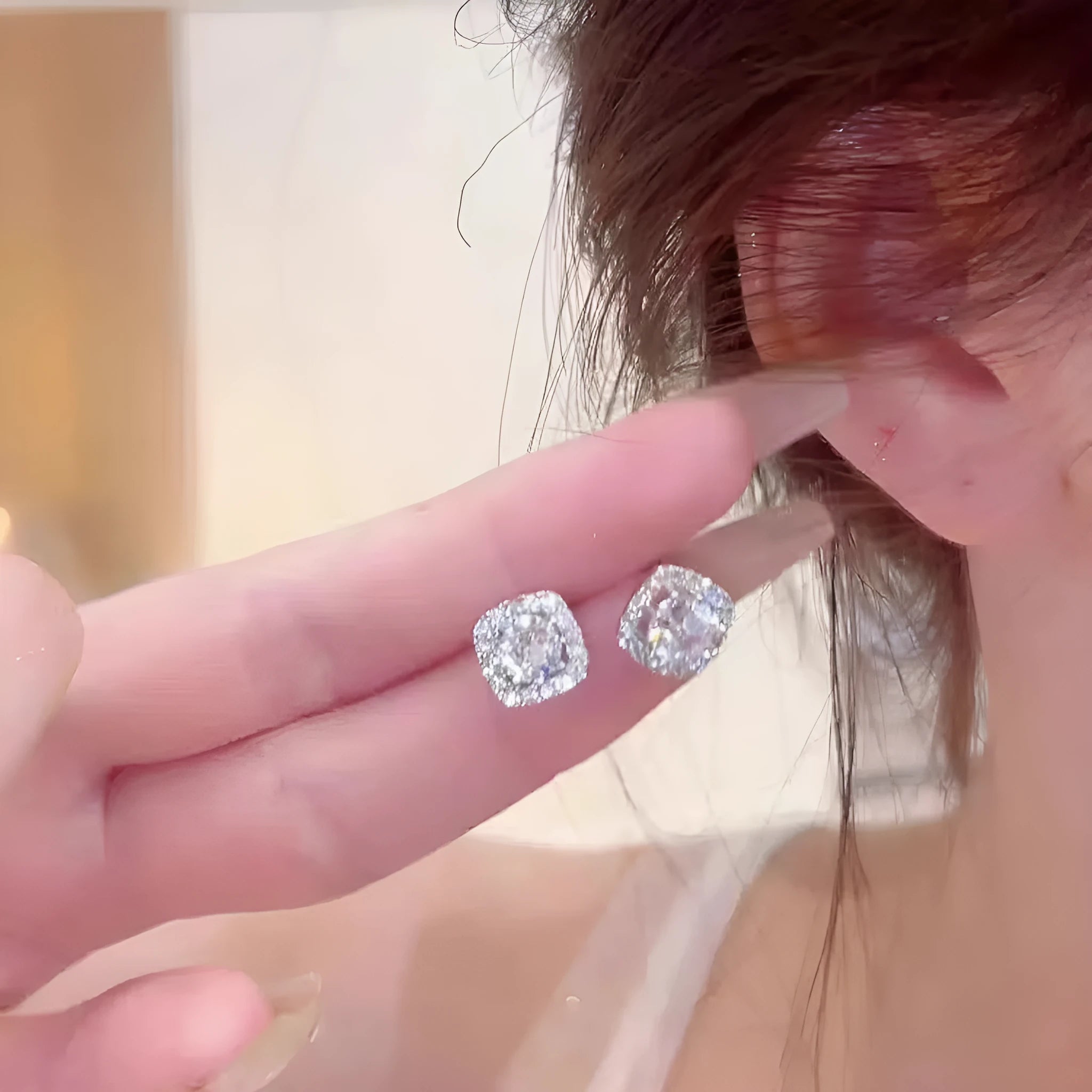 A pair of square geometric diamond-treated alloy earrings on a silver or gold background.