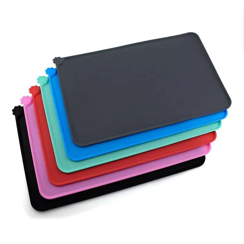 Silicone pet placemat for under food bowls in blue, shown next to a dog bowl.